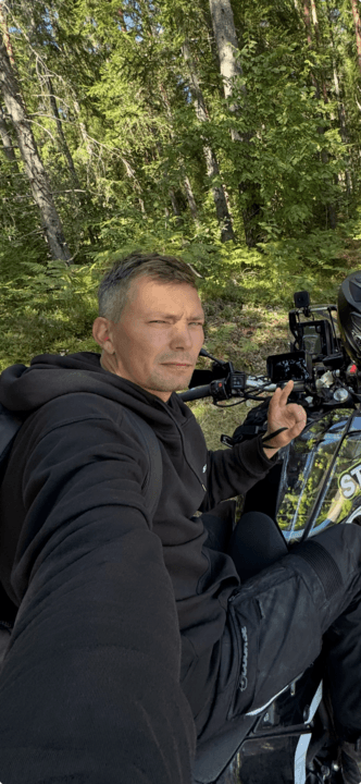 Niclas Tingström sitting on a motorcycle with in the woods